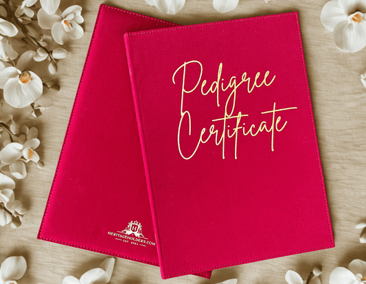 Red 'Pedigree Certificate' holder with white text on a wooden surface with flowers.