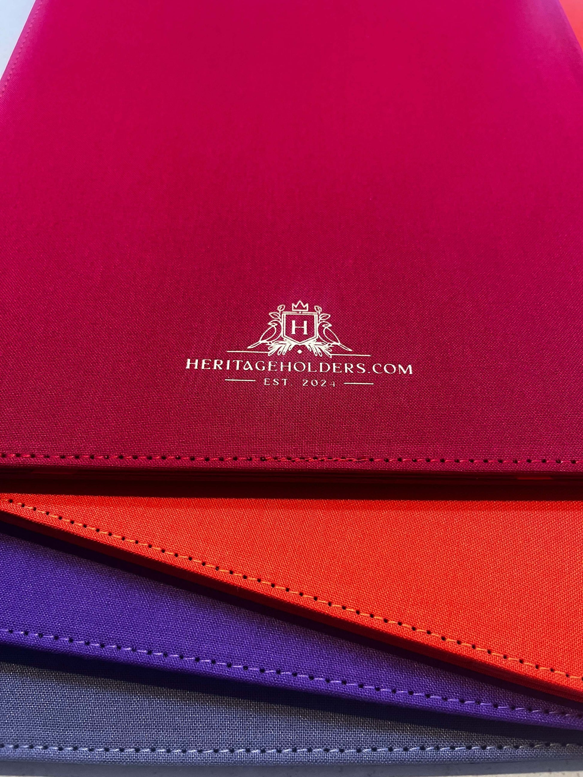Close-up of a red leather product with 'Heritage Holders' logo and text.
