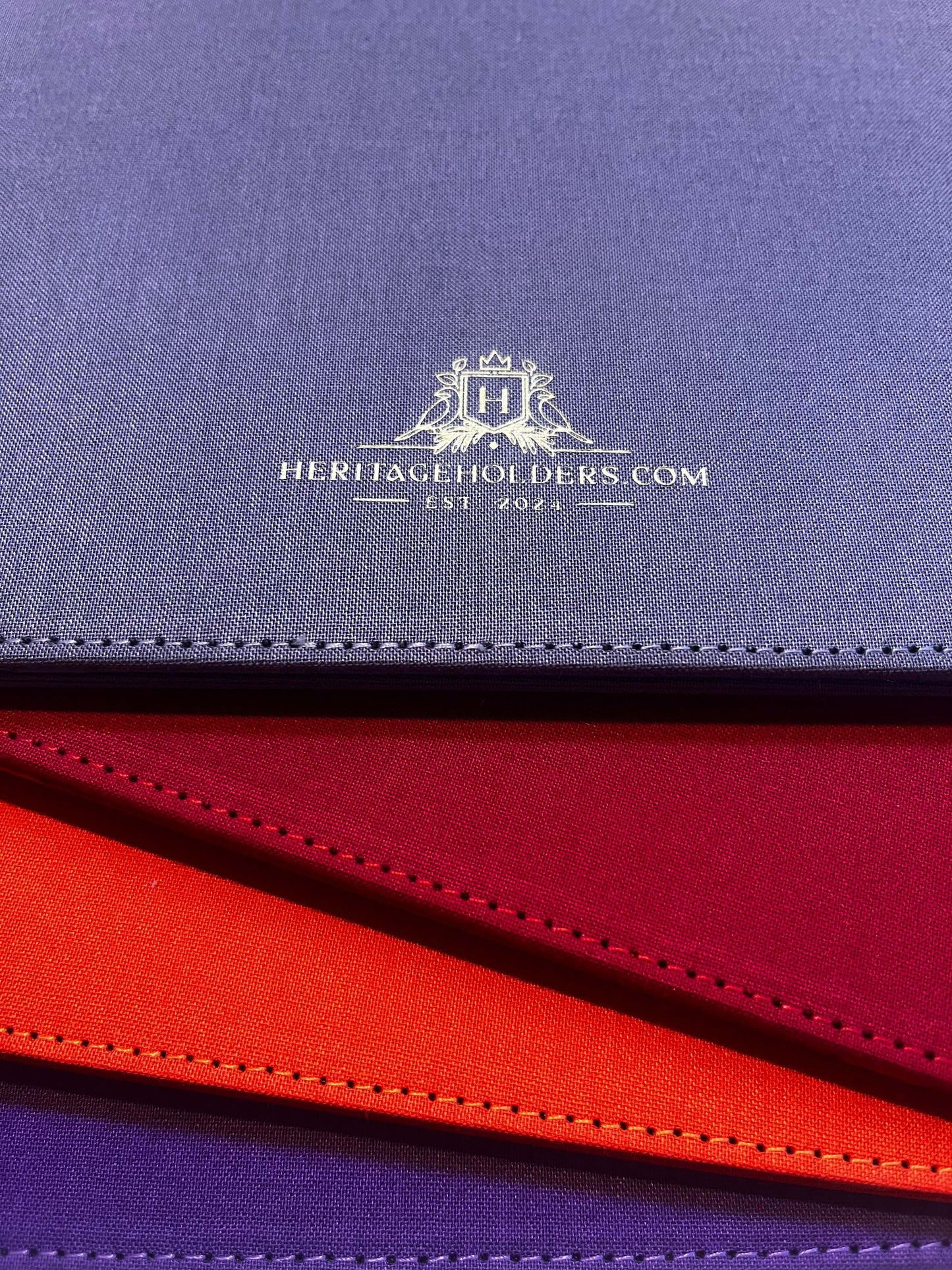 Close-up of a blue, red, and purple fabric with a brand logo and text.